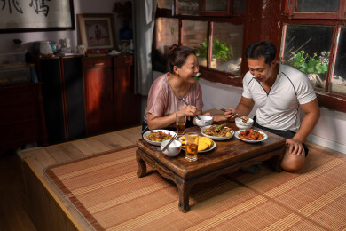 一对农民夫妇坐在炕上用餐