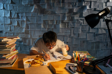 疲惫的学生在浩瀚的书海中写作业