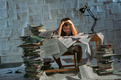 疲惫的学生在浩瀚的书海中写作业