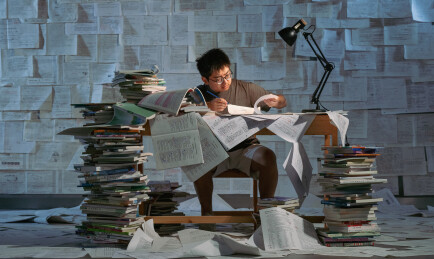 疲惫的学生在浩瀚的书海中写作业