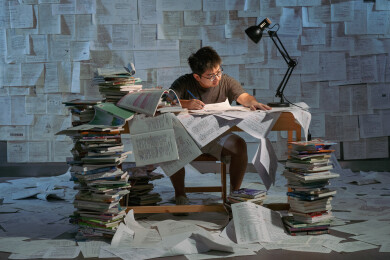 疲惫的学生在浩瀚的书海中写作业