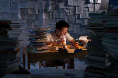 疲惫的学生在浩瀚的书海中写作业