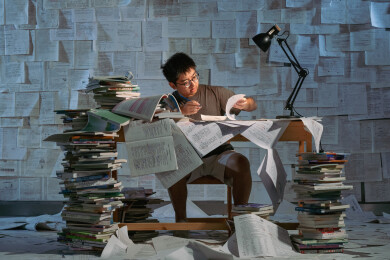 疲惫的学生在浩瀚的书海中写作业