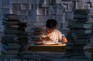 疲惫的学生在浩瀚的书海中写作业