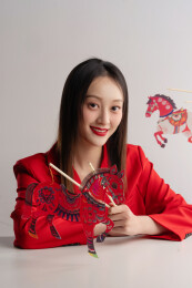 传统服饰女子持马年皮影