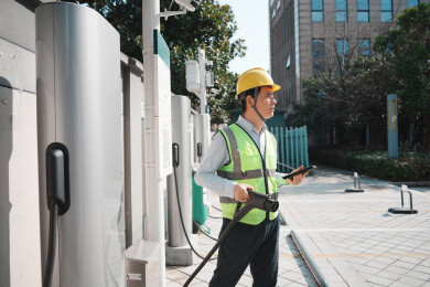 戴安全帽男子手持充电枪操作充电桩