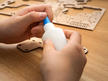 双手操作胶水粘合木质拼图