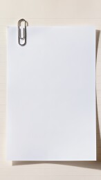 白色纸张被金属回形针固定在浅色背景上