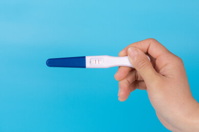 手拿验孕棒特写蓝色背景