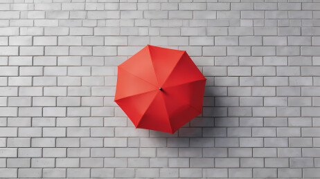 鲜红雨伞映灰墙