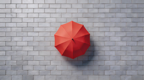 鲜红雨伞映灰墙