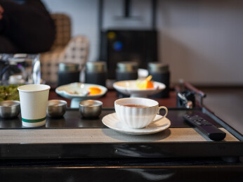 茶盘上摆放着茶具茶点和遥控器