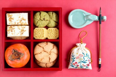 红色食盒盛放点心柿子与文房用具