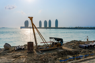 三亚凤凰岛港口码头建设现场多台挖掘机作业