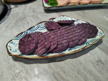 餐桌上盘子里的火锅新鲜食材紫土豆切片