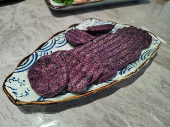 餐桌上盘子里的火锅新鲜食材紫土豆切片