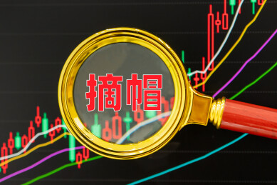 放大镜聚焦摘帽字样股市图表背景