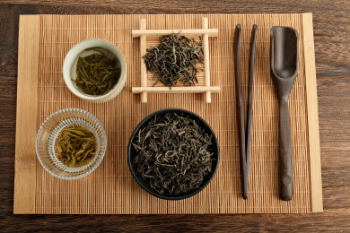 竹席上摆放茶具与各类干茶叶