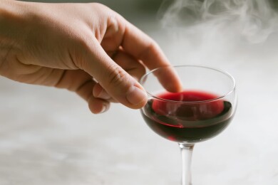手握红酒杯，酒液微烟