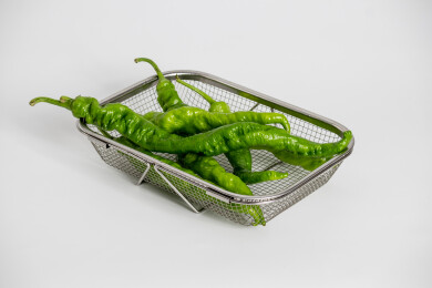 白色背景上金属菜篮子里的螺丝椒辣椒食材