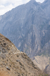 虎跳峡陡峭山崖上徒步者穿行险峻山路