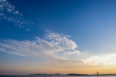 黄昏的海景，平静的沿海水域上点缀着云朵