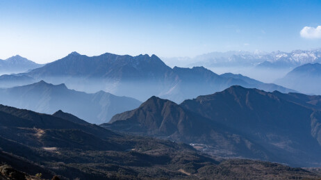 四川华尖山，晴空下薄雾缠绕的蓝调层叠山峦