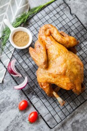 烤鸡置于冷却架上配香料蔬菜