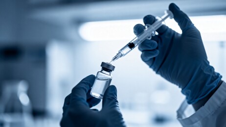 医护人员抽取疫苗瓶药液