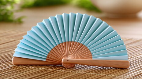 蓝色折扇置于竹席之上