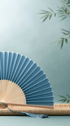 蓝色折扇置于竹席之上