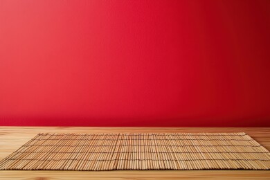 红色背景下木制桌面上平铺着竹席，产品展示