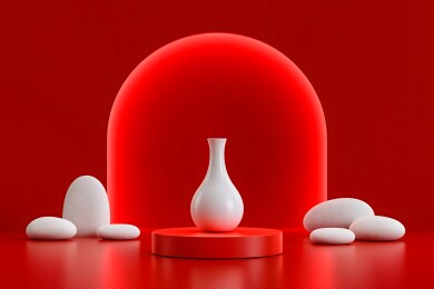 红背景下的白色花瓶和鹅卵石