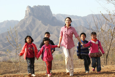 女老师带领学生在山间小路上行走