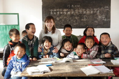 乡村小学女教师与学生在教室内快乐合影