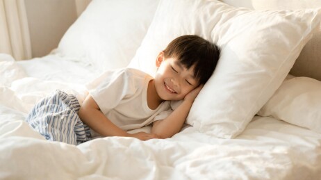 小男孩床上微笑安睡