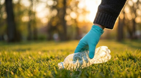 户外草地戴手套捡拾塑料瓶环保行动