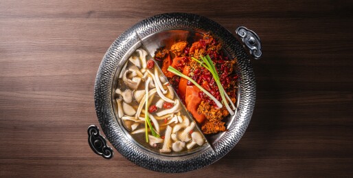 黑砖墙暗调木桌的菌汤鸳鸯锅