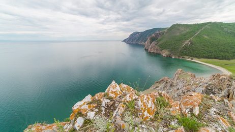 thai long tail boat with tourists sailing near big mountain.