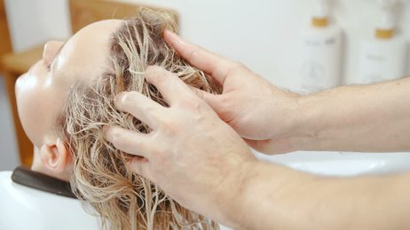 youngwomantakingfoambathandwashhairbyshampooinherbathroom