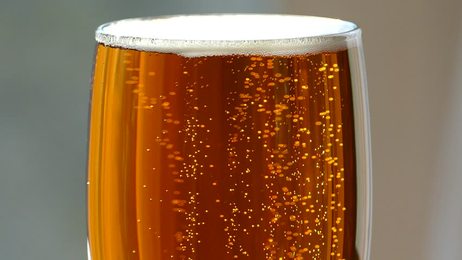 cold light beer in a glass with water drops.