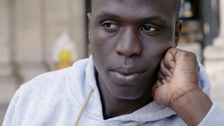 hungryyoungmangreedilyeatinghamburgerandfrenchfriesinfastfood