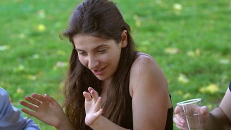 happywomansittingonthemeadowandusingtablet