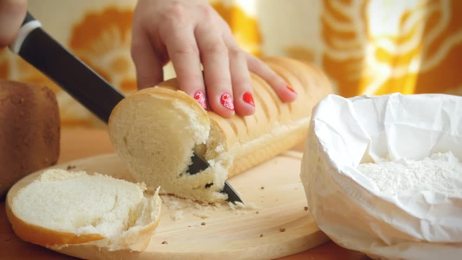 womankneadthedoughandcuttingitintoslicespreparationofdumplings