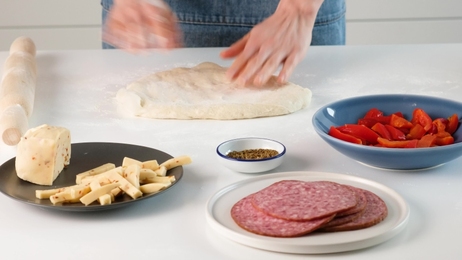 womankneadthedoughandcuttingitintoslicespreparationofdumplings