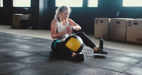 sexy asian young woman working out does kettlebell swings in the