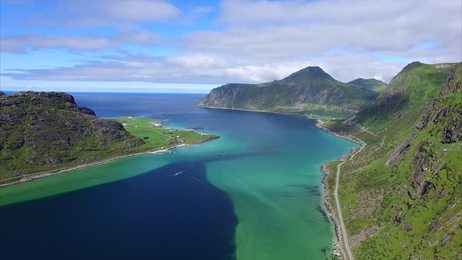 thai long tail boat with tourists sailing near big mountain.