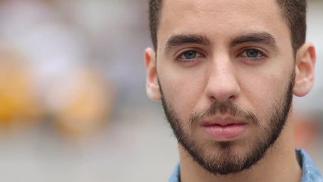 handsome smiling man with pink hair and beard is winking at